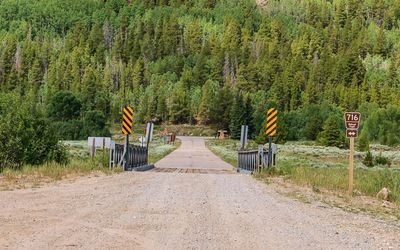 View over the Eagle River bridge with the camp entrance in the distance in Camp Hale NM