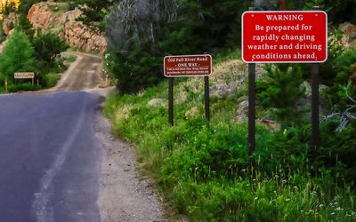 Warning signs at the entrance to the dirt Old Fall River Road in Rocky Mountain NP