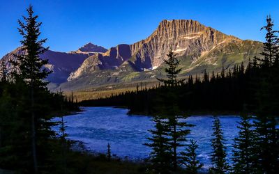 A river runs by towering mountains in Jasper NP