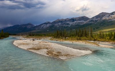 Clouds form over the mountains and the Kootenay River from the Simpson Trail Bridge in Kootenay NP