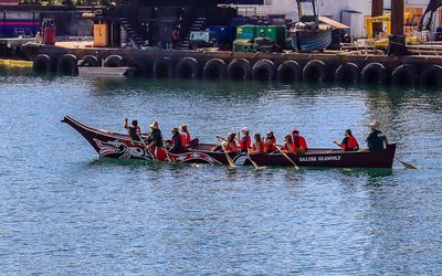 First Nations sea boat paddling through the Victoria inner harbor on the Whale Watching Tour