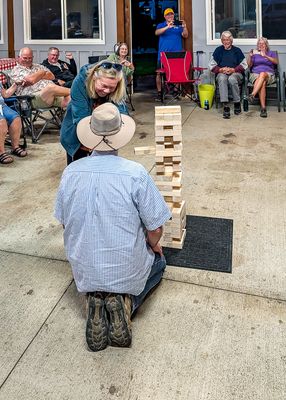 Leslie and Greg debate strategy in the Jenga competition