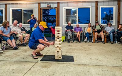 George carefully checks for a weak spot in the Jenga competition