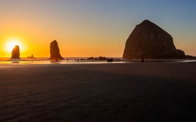 Sun behind one of the Needles from on Cannon Beach