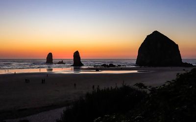 The Needles and Haystack Rock silhouetted against the darkening horizon as seen from above Cannon Beach