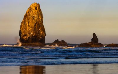 One of the Needles is illuminated by the rising sun on Cannon Beach