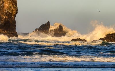 Waves crash onto the rocks at sunrise on Cannon Beach