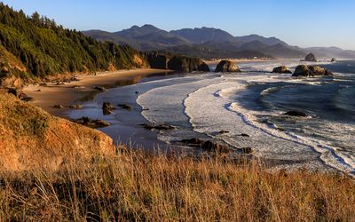 Surf washes up on the beach as the sun sets on Ecola State Park along the Oregon Coast