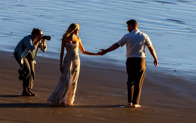 Photographer takes portraits of a couple on the beach in Ecola State Park along the Oregon Coast