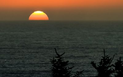Sun sinking below the horizon as seen from Ecola State Park along the Oregon Coast