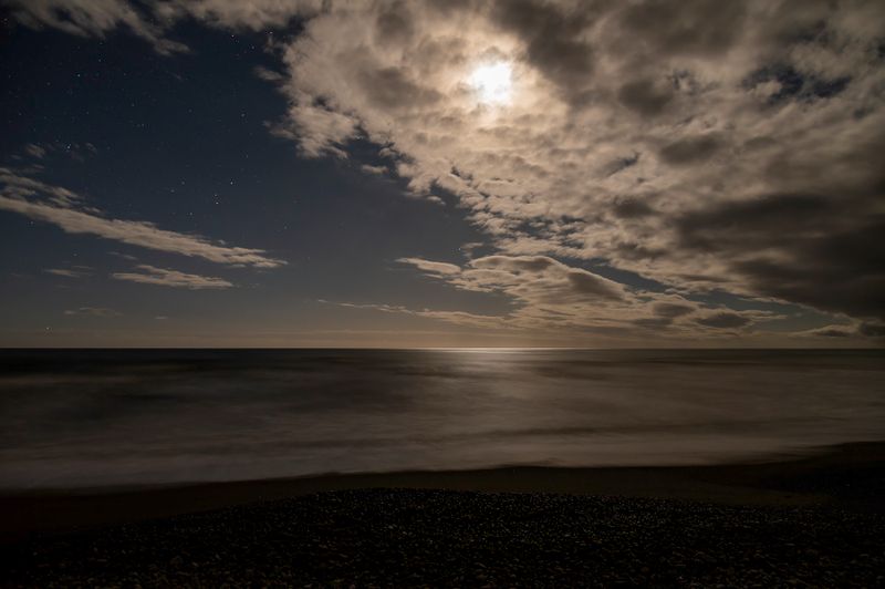 Gibbous moon, hidden by clouds, heading to setting