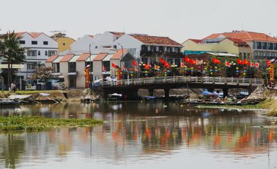 Hoi An bridge with flags & water reflections