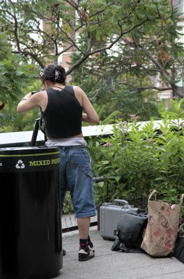 A woman photographing something from the High Line was making a fashion statement. 