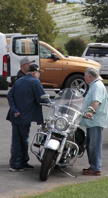 Mike, his son, and Howard discuss the motorcycle