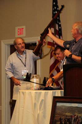 John accepting rifle for son Chuck, who won the popular raffle