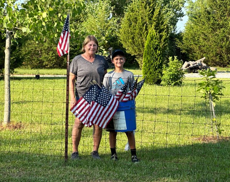 Brenda and AJ taking down the 24 flags we had on our fencepost