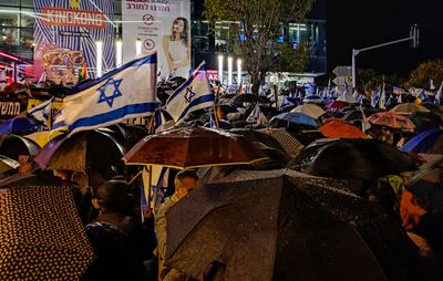 Demonstrators protest on a rainy evening against the constitutional cue in Israel