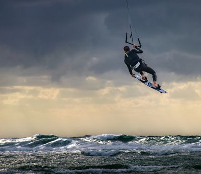 A kite surfer takes off on a stotrmy afternoon