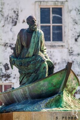 A primitiva escultura de Armando Coelho sofreu algumas vicissitudes. Durante anos a imagem em gesso esteve no Museu Municipal, tendo a sua passagem a bronze sido orientada por Ruy Anahory. Na noite de S. Pedro de 1996 foi, finalmente, colocada onde melhor fica expressa a ligação entre este Santo e os seus devotos poveiros – sobranceira ao porto de pesca. S. Pedro lança a rede de face voltada para o mar, em atitude de vigília e inspirando os seus irmãos pescadores.
( https://www.povoabeirizargivai.pt/index.php/monumentosescultoricos/ )