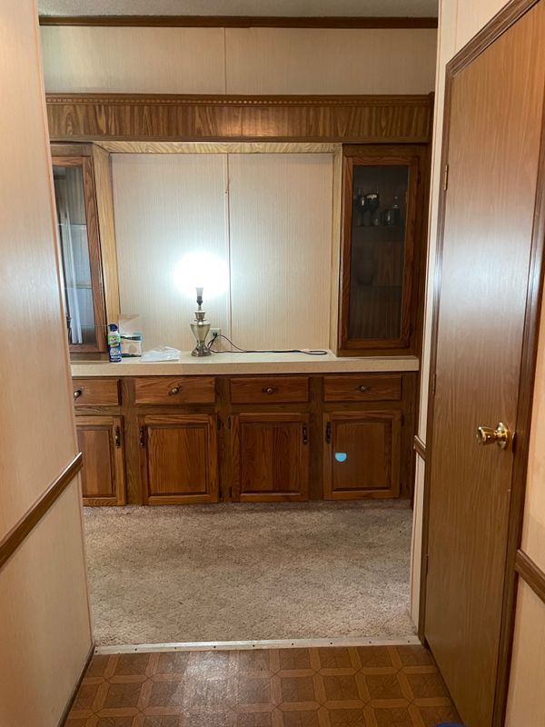 At the end of the foyer is cabinetry with storage, drawers, and display cabinets.