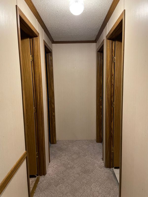 View down hall, bathroom left, laundry room right, 2nd bedroom back left, 3rd bedroom back right