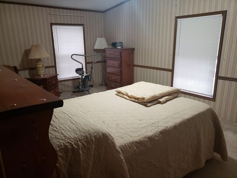 Primary bedroom, which you enter just past the foyer. Bedroom and bathroom are 28 ft, across entire front of home.