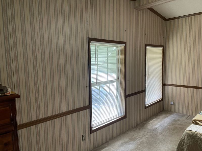 Standing near the double doors, the front windows, past the tall dresser in earlier photos.