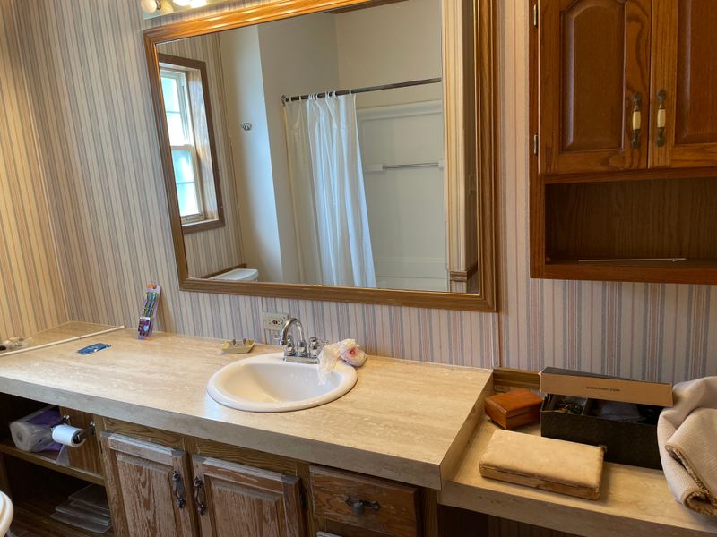 Primary bathroom vanity needs work! Shower in mirror has leak, so it and the floor need to be replaced.