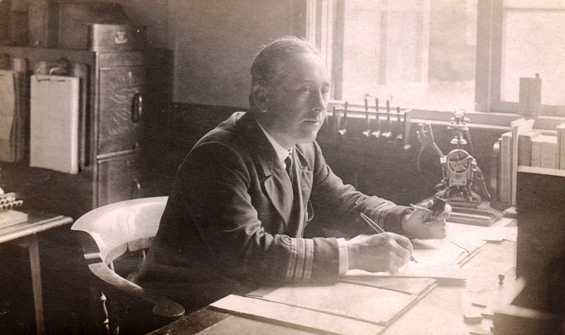 1921, 28TH MAY - ARTHUR E BRADSHAW, COMMANDER McMAHON, AT HIS DESK.jpg