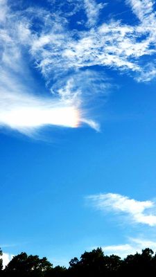 Rainbow colored cloud on a sunny afternoon