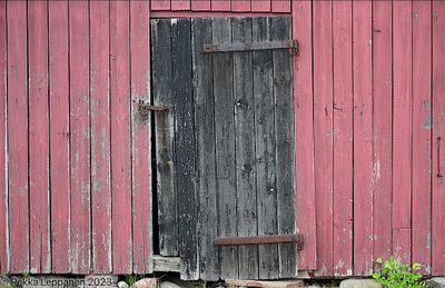 Black door on a red barn wall
