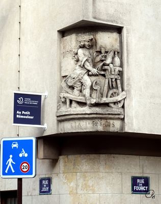 Le Remouleur bas-relief in the Marais, originally a sign for a wine/spirit merchant named Au Gagn-Petit