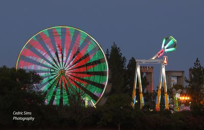 Ferris wheel and carnival rides at the California state fair. View from the parking lot.