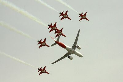 Patrouille Suisse with six F-5 E Tiger aircraft in formation with a Helvetic Embraer E190-E2