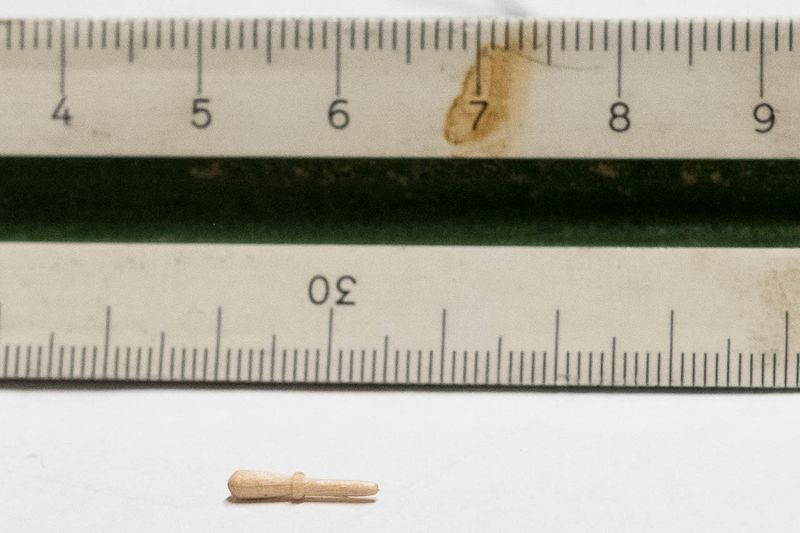 En kuffernagle av tre. Den er ogs laget p dreiebenk, men han har da brukt en liten fil til  forme den mens den spinner.