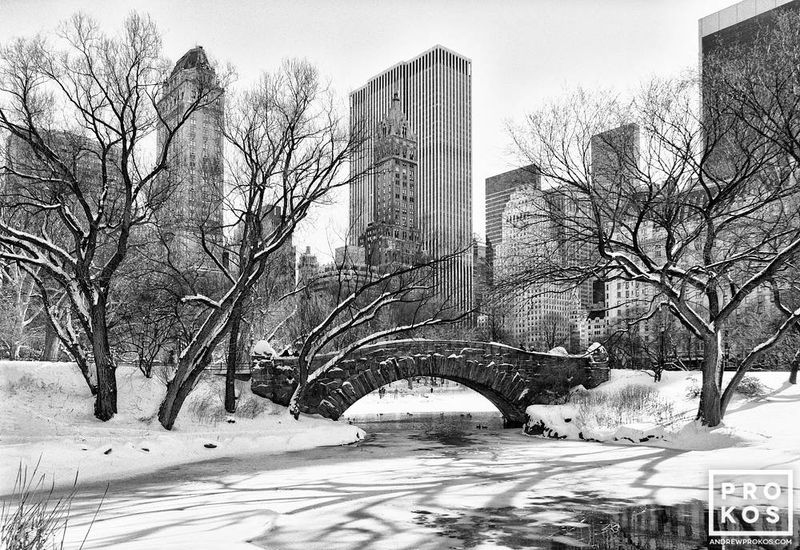 Black and white photo of a winter landscape of Gapstow Bridge and the Pond in winter in Central Park by master art photographer Andrew Prokos. Limited edition prints of this photo are available up to 60 inches in width. Ships from the artist's New York photo gallery