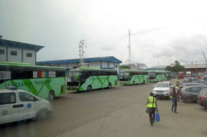 Caravan of tour buses led by motorcycle policemen in Abidjan, Ivory Coast.JPG