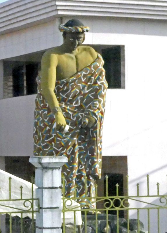 Statue of servant pouring a drink stands in front of the residence of the King of Grand Bassam, Ivory Coast.JPG