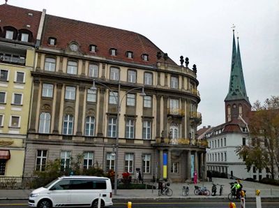 Restored building in Berlin with twin spires of St. Nicholas Church Museum in the background