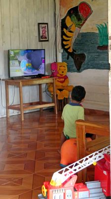 Boy watching cartoons in small Amazon village