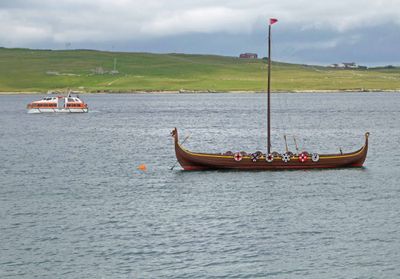 An Island Princess tender passing a 'viking ship' on Bressay Sound