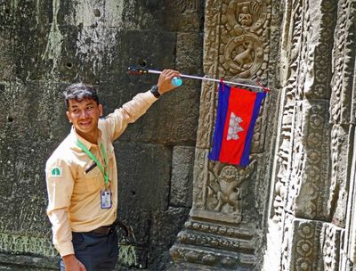Our guide, Chan, with the Cambodian Flag at Ta Prohm Temple