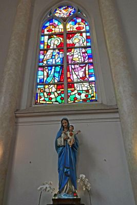 Stained glass above statue of Mary with Jesus in the Birth of Blessed Virgin Mary Church in Surabaya, Indonesia