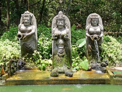 Three Aspari statues in the Monkey Forest give blessings to the fertility of the world