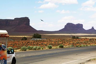 A hawk soars over Monument Valley