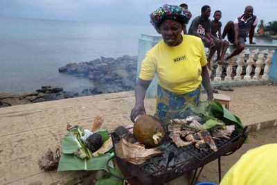 Grilling fish and roasting Breadfruit for us to taste in Pntufo, Sao Tome.JPG