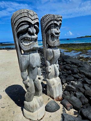 Two images stand as guardians on the shore of Puʻuhonua o Hōnaunau