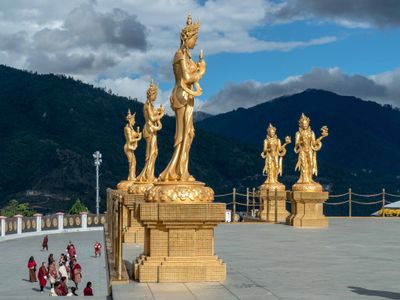 Thimpu - statues of goddess around Buddha monument.