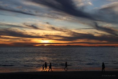 Crystal Cove sunset showing Catalina and beachgoers