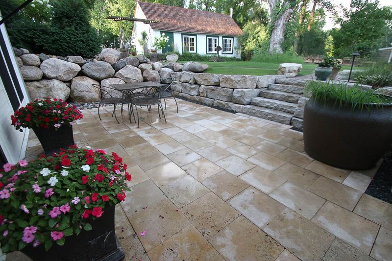 Sunken-limestone-patio-from-walkout-lower-level-surrounded-by-boulder-and-limestone-retaining-walls MLR2023.jpg